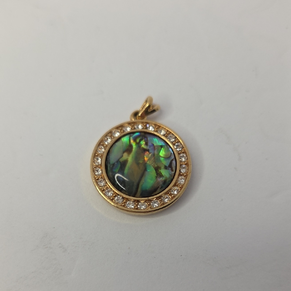 Nina Ricci round abalone shell pendant set in a gold-plated frame w/rhinestones